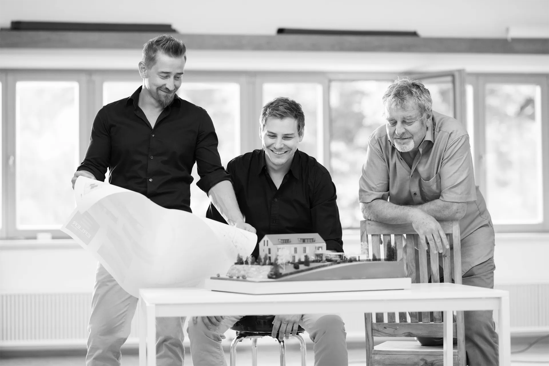 Das Team von Erler Haus bespricht ein Modell des Doppelhauses